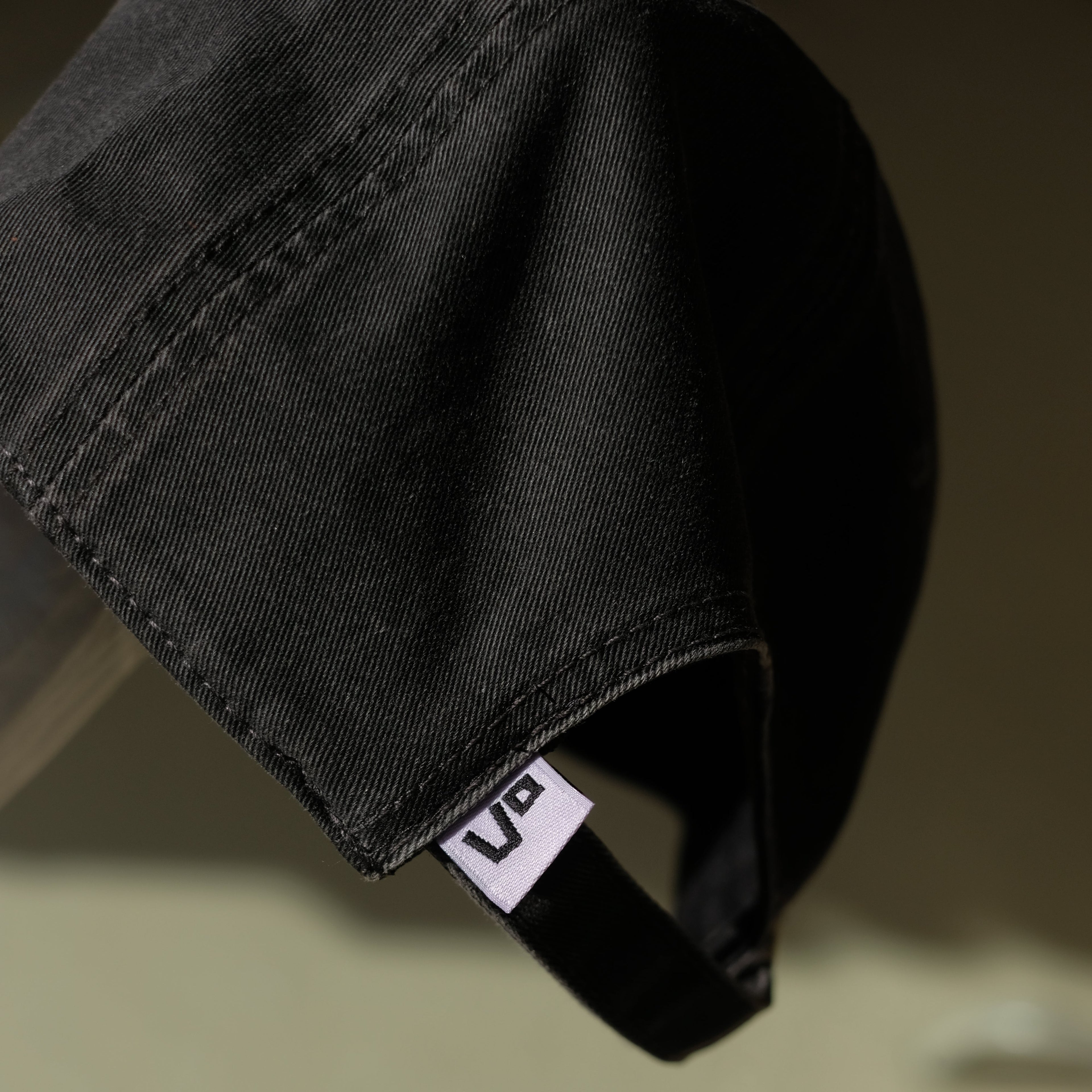 Black cap with a visible brand logo on a blurred background